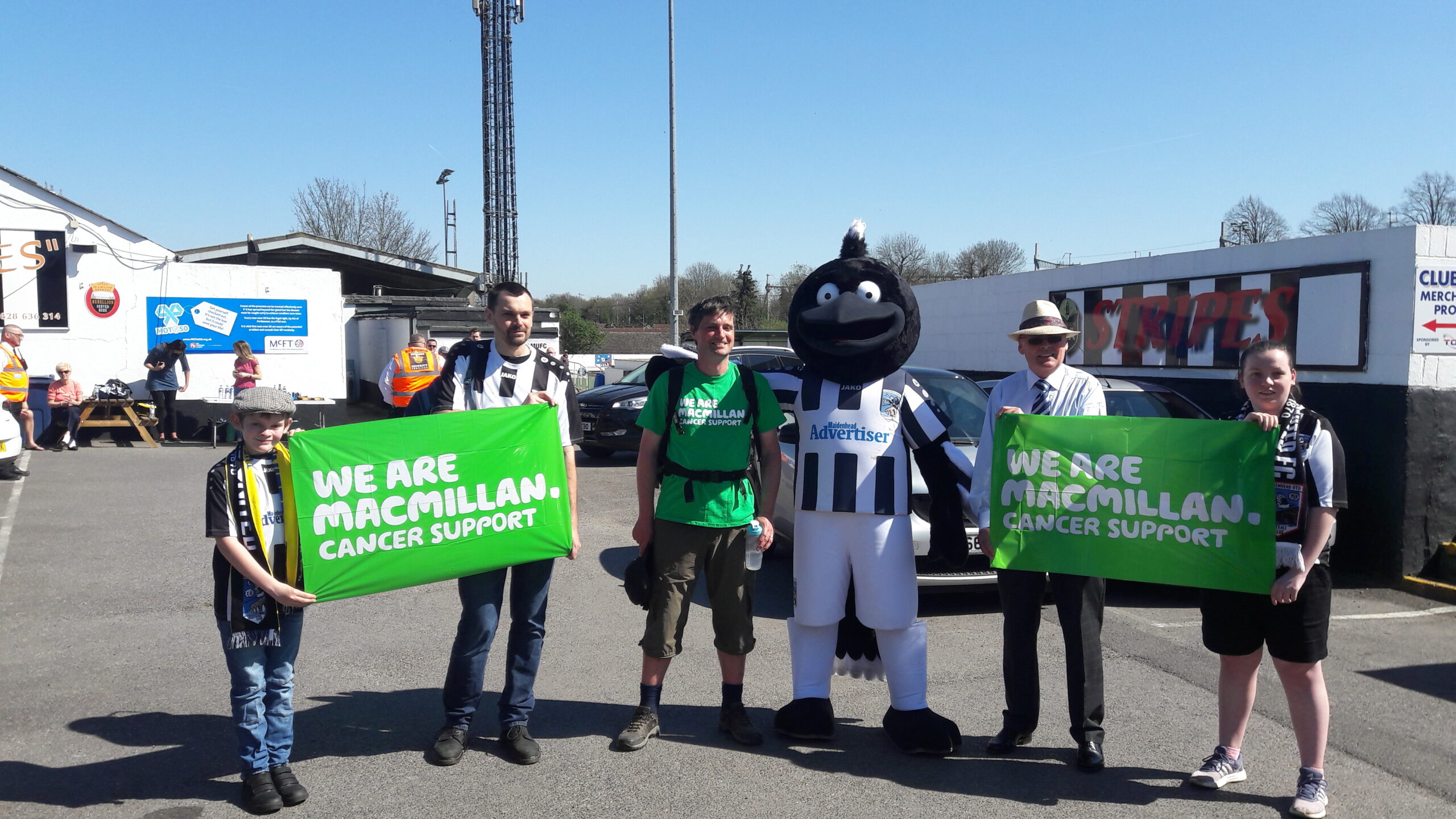 A photo of Sarah's husband, the 7 foot magpie mascot and other supporters outside the ground at the end of his charity challenge