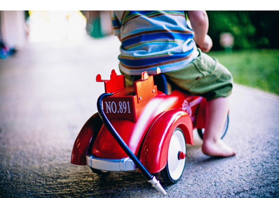 Young child sitting on a toy fire engine