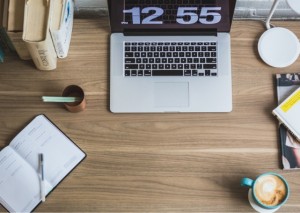 Picture of the top of a desk with laptop, books etc