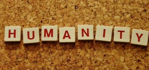 Scrabble tiles spelling out the word humanity on a cork board