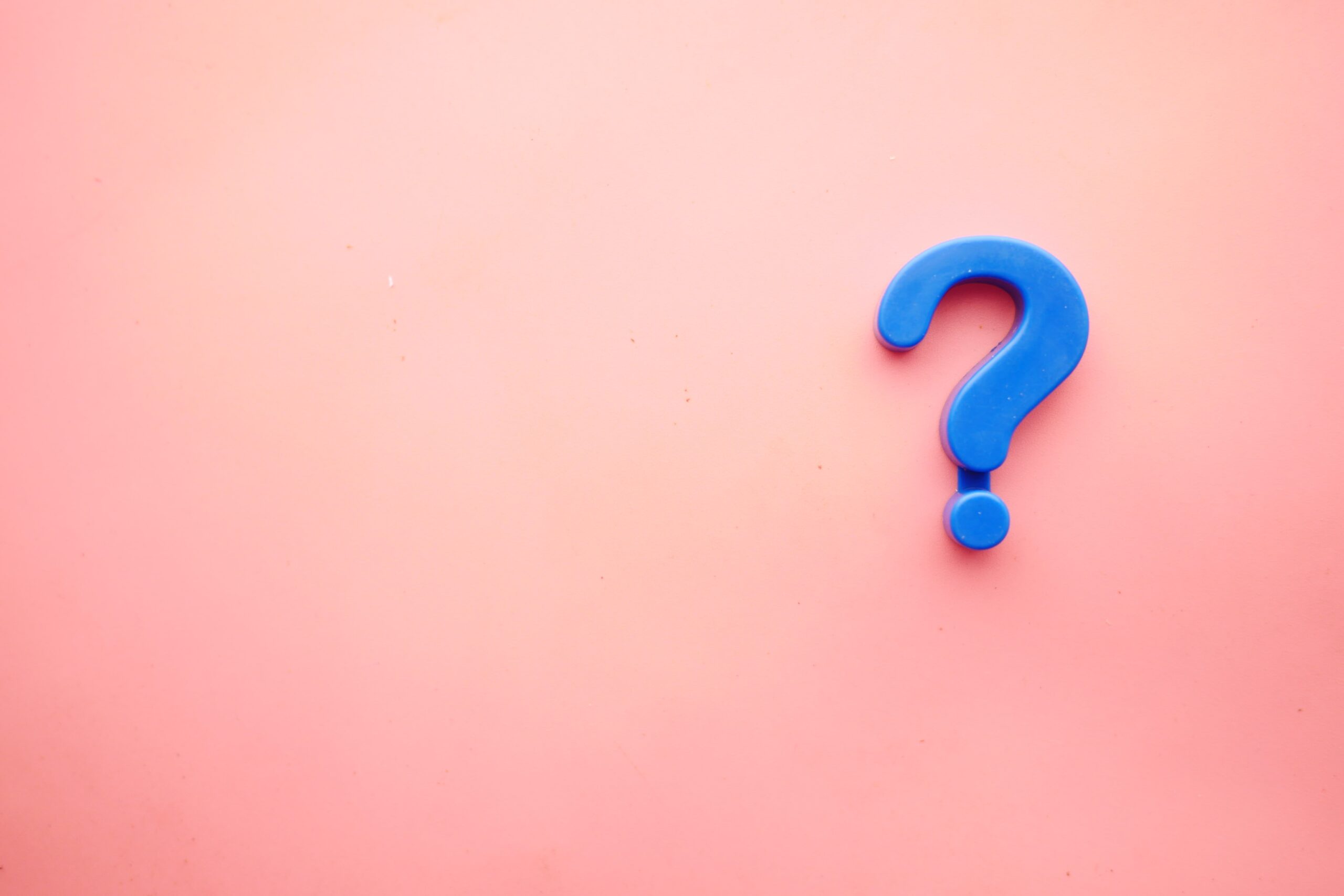 A blue question mark against a pink background