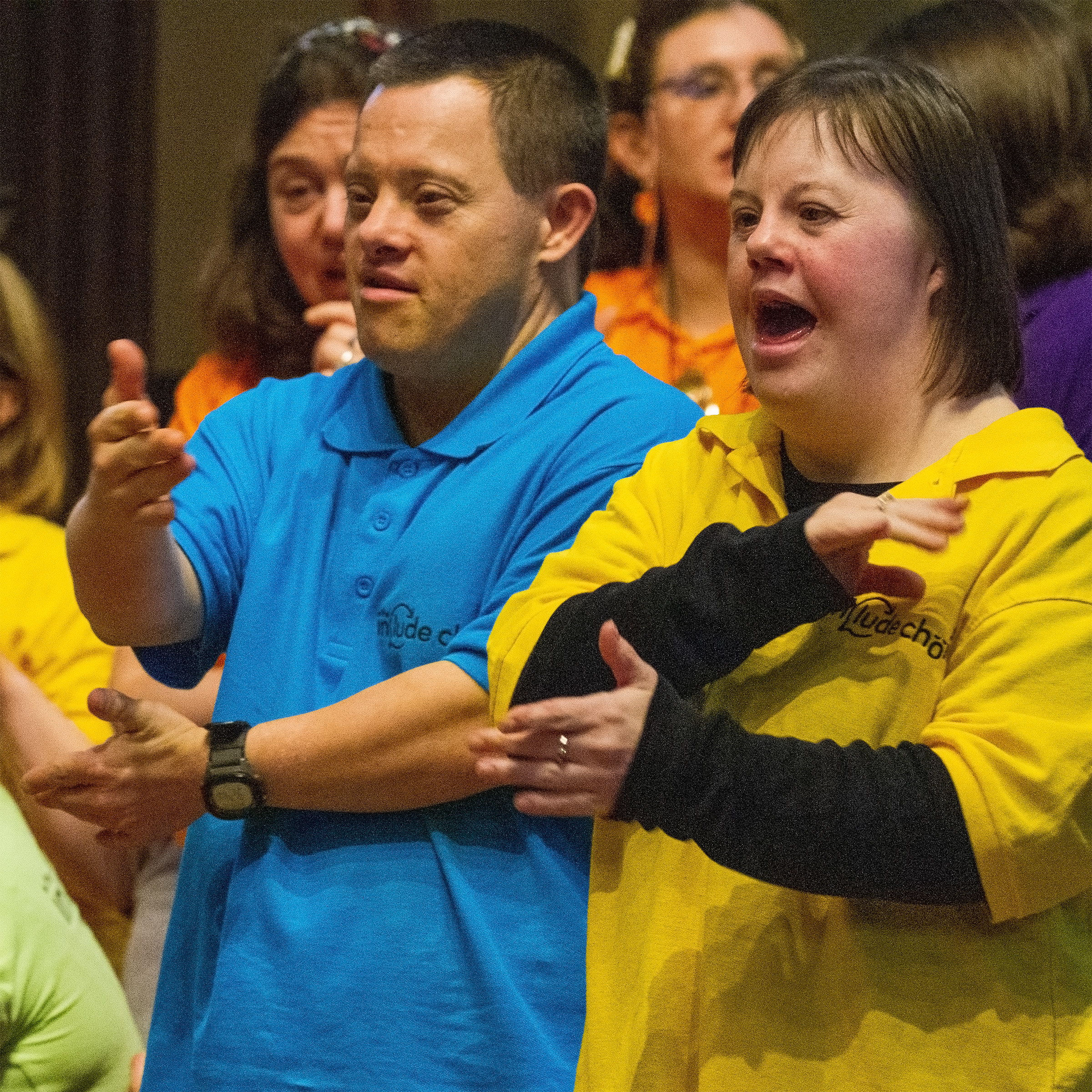 2 members of the Include Choir, looking joyful and signing the song about kind communication